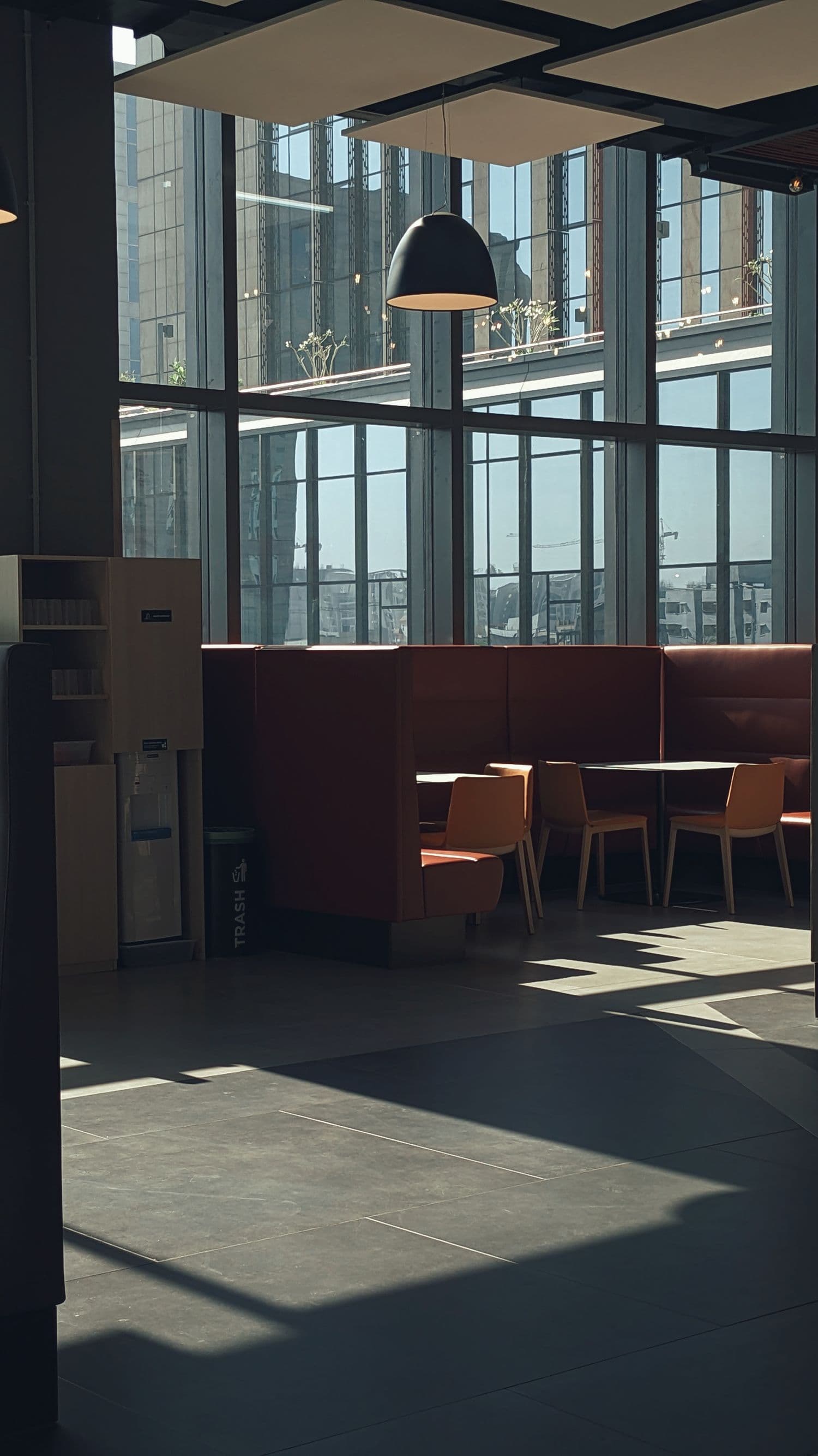 Sunlit office seating area with booths and tables